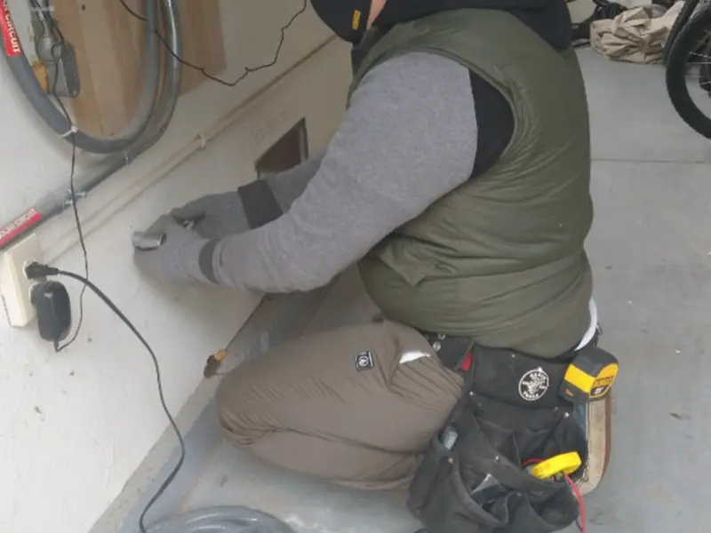 Electrician performing outlet wiring in a Kensington Park garage